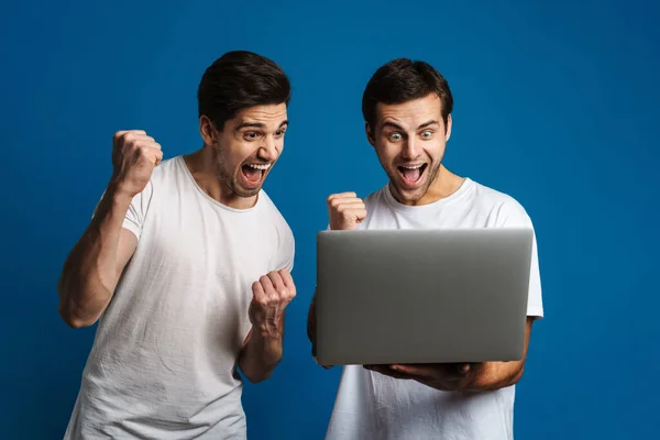 Emocionado Dois Caras Fazendo Gesto Vencedor Enquanto Posando Com Laptop — Fotografia de Stock