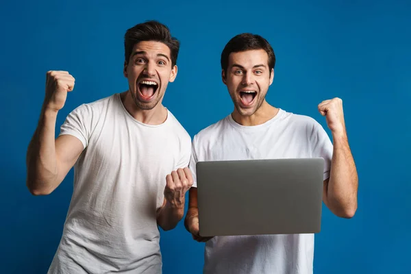 Emocionado Dois Caras Fazendo Gesto Vencedor Enquanto Posando Com Laptop — Fotografia de Stock