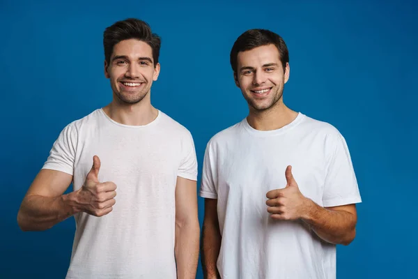 Joyeux Beaux Gars Souriant Montrant Pouces Isolés Sur Fond Bleu — Photo