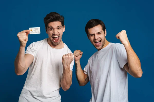 Emocionado Dois Caras Fazendo Gesto Vencedor Enquanto Posando Com Cartão — Fotografia de Stock