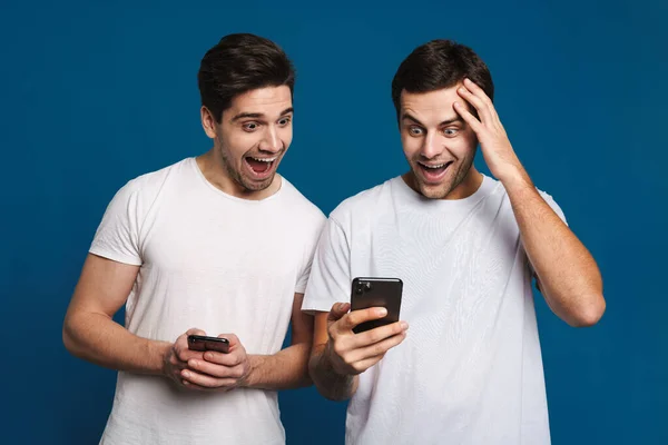 Encantado Dos Chicos Que Expresan Sorpresa Mientras Posan Con Teléfonos — Foto de Stock