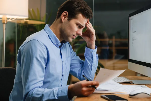 Pensive Attractive Young Entrepreneur Looking Paperwork While Sitting Desk — Stock Photo, Image