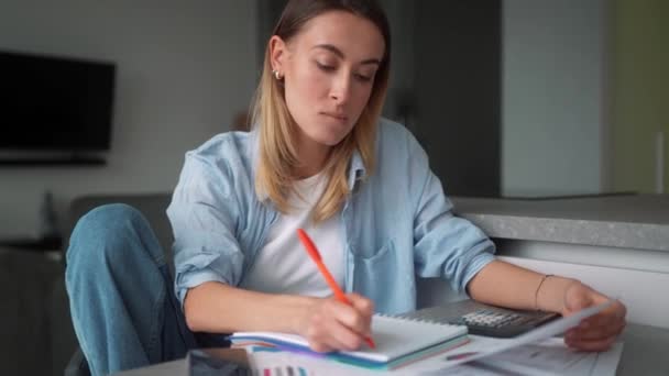 Mujer Pensativa Comprobando Las Cantidades Billetes Una Calculadora Mientras Está — Vídeo de stock