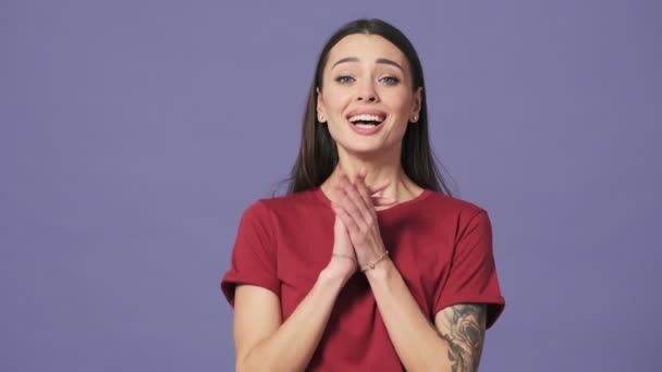 Memnun Genç Bir Kadın Ellerini Çırpıyor Stüdyonun Mor Arka Planında — Stok video
