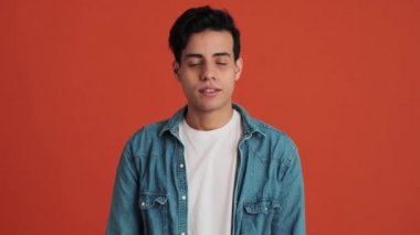 Turuncu stüdyoda dikilirken sürpriz yapan mutlu bir Arap.