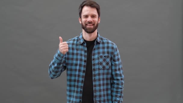 Hombre Risueño Con Camisa Cuadros Mostrando Pulgar Lado Estudio Gris — Vídeos de Stock