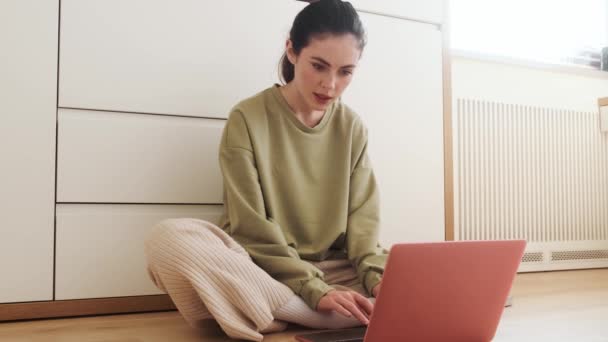 Mulher Concentrada Digitando Teclado Laptop Enquanto Senta Chão Sala — Vídeo de Stock
