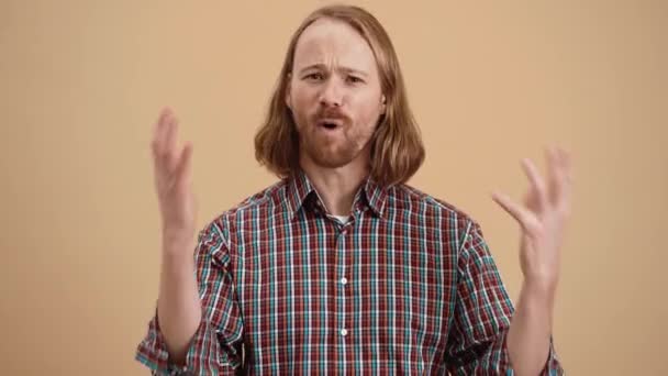 Uzun Saçlı Ekose Gömlekli Kızgın Adam Bej Renkli Bir Stüdyoda — Stok video
