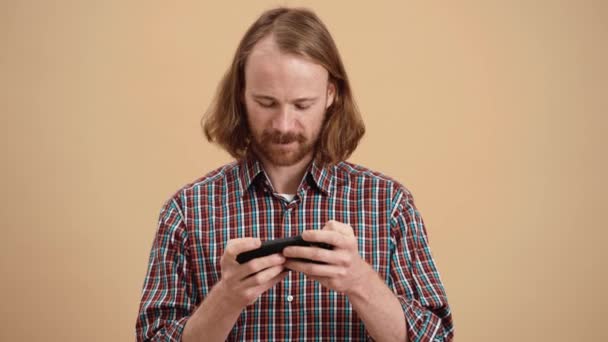 Homem Com Cabelos Longos Uma Camisa Xadrez Jogando Jogo Telefone — Vídeo de Stock