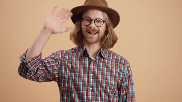Ένας Χαμογελαστός Άντρας Καπέλο Και Γυαλιά Χαιρετάει Την Κάμερα Ενώ — Αρχείο Βίντεο