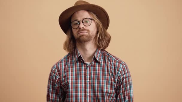 Der Müde Mann Mit Hut Und Brille Blickt Einem Beigen — Stockvideo