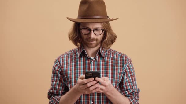 Hombre Riendo Sombrero Las Gafas Escribiendo Teléfono Mientras Está Pie — Vídeo de stock