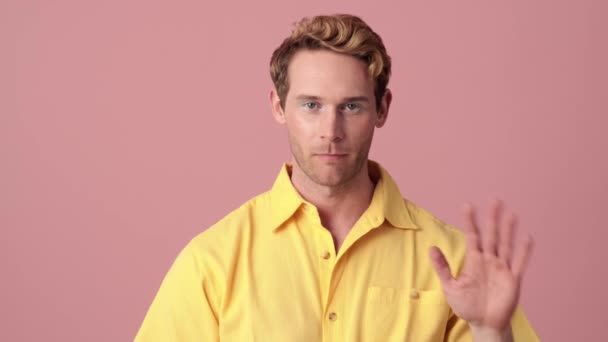 Sarı Gömlekli Kendine Güvenen Bir Adam Pembe Bir Stüdyoda Dikilirken — Stok video