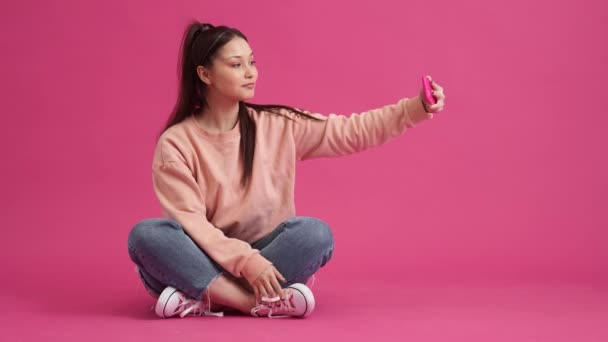Pozytywna Młoda Nastolatka Robi Sobie Selfie Pomocą Smartfona Siedzącego Podłodze — Wideo stockowe