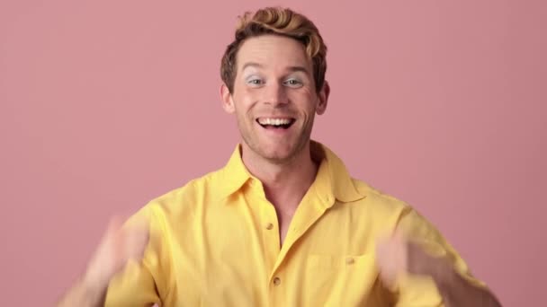 Χαμογελαστός Άντρας Μακιγιάζ Χαίρεται Σηκωμένα Χέρια Ένα Ροζ Στούντιο — Αρχείο Βίντεο
