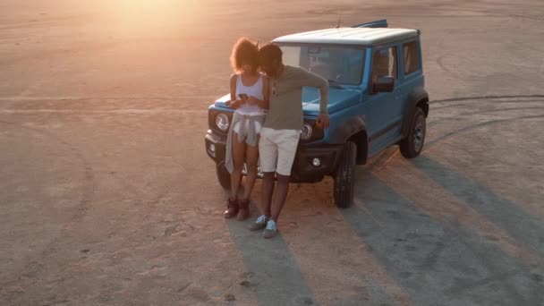 一对快乐的夫妇站在大自然的汽车旁边看着电话的俯瞰画面 — 图库视频影像