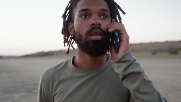 Het Close Uitzicht Van Afrikaanse Geconcentreerde Man Praten Aan Telefoon — Stockvideo