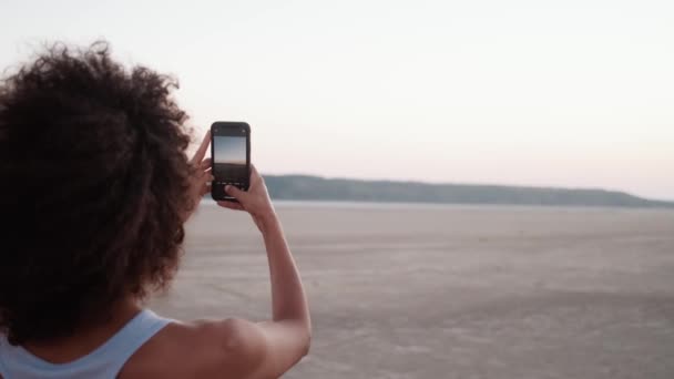 Задньому Плані Африканка Робить Фотографію Заходу Сонця Телефону Природі — стокове відео