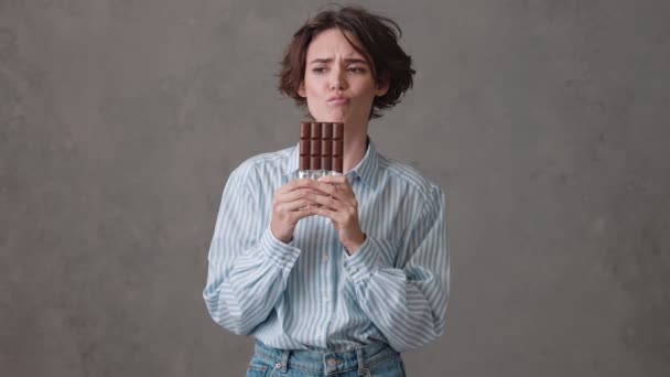 Una Mujer Molesta Con Pelo Corto Sosteniendo Una Barra Chocolate — Vídeos de Stock