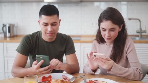 Das Lächelnde Paar Schaut Aufs Telefon Und Frühstückt Während Der — Stockvideo