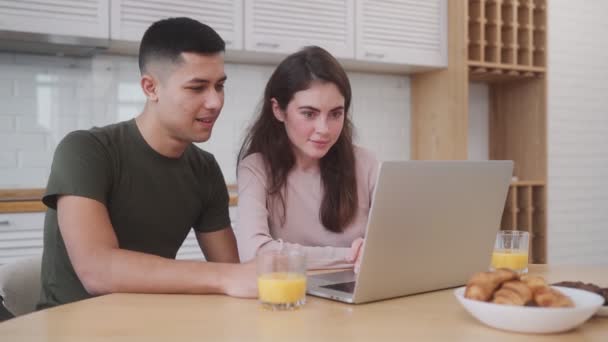 Casal Positivo Olhando Para Algo Laptop Tomando Café Manhã Enquanto — Vídeo de Stock