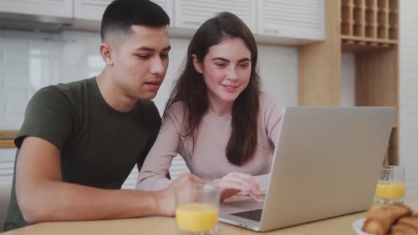 Vista Lateral Pareja Sonriente Escribiendo Algo Portátil Desayunando Mientras Está — Vídeo de stock