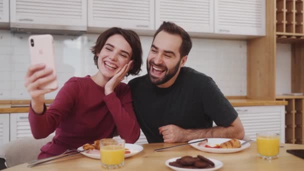 Olumlu Genç Bir Çift Kahvaltı Sırasında Evde Mutfaktaki Masada Oturup — Stok video