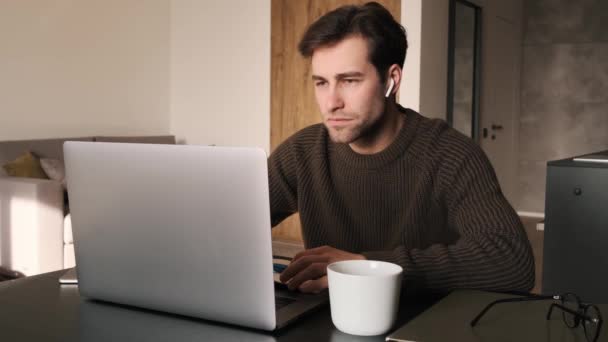Συγκεντρωμένος Άνθρωπος Πληκτρολογώντας Κάτι Στο Φορητό Υπολογιστή Ενώ Κάθεται Στο — Αρχείο Βίντεο