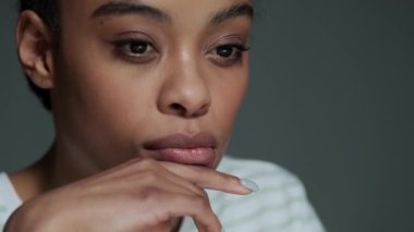 Düşünen Amerikalı bir kadının yakın plan görüntüsü ofiste otururken bilgisayarını kullanıyor.