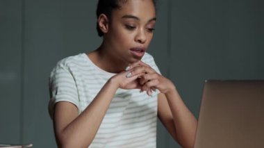 Güzel bir Amerikalı kadın ofiste oturmuş bilgisayarını kullanarak video bağlantısıyla konuşuyor.