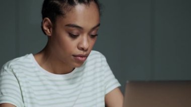 Güzel bir Amerikalı kadın bilgisayarını kullanıyor. Sonra ofiste oturan kameraya bakıyor.