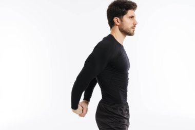 Genç sporcu, beyaz arka planda tek başına çalışırken egzersiz yapıyor.