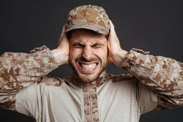 Mutsuz Erkeksi Asker Siyah Arka Planda Kulaklarını Kapatırken Yüzünü Buruşturuyor — Stok fotoğraf