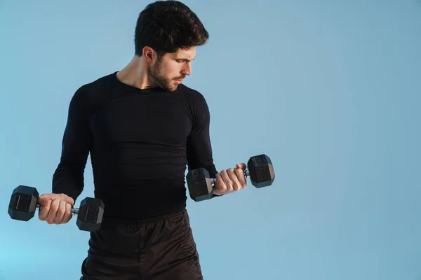 Beau Sportif Travaillant Avec Des Haltères Isolés Sur Fond Bleu — Photo