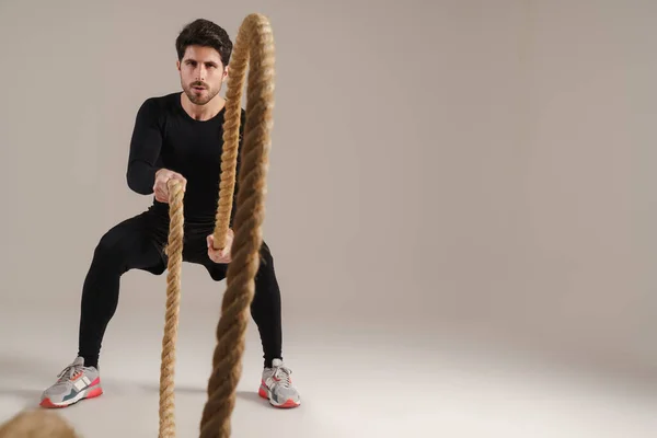 Guapo Deportista Atlético Haciendo Ejercicio Con Cuerdas Batalla Aisladas Sobre —  Fotos de Stock