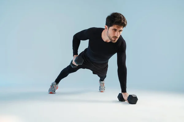 Beau Sportif Travaillant Avec Des Haltères Isolés Sur Fond Bleu — Photo