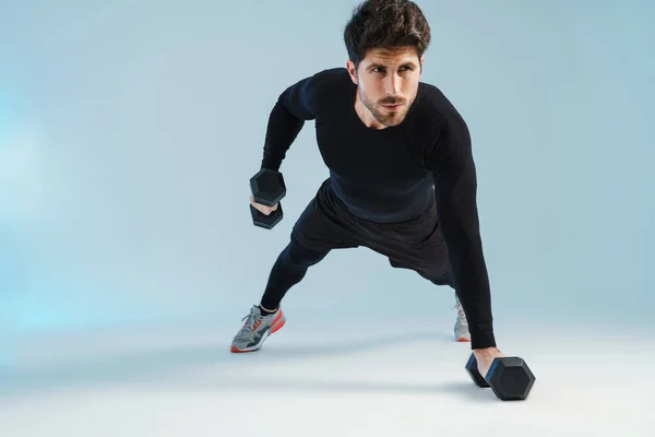 Beau Sportif Travaillant Avec Des Haltères Isolés Sur Fond Bleu — Photo