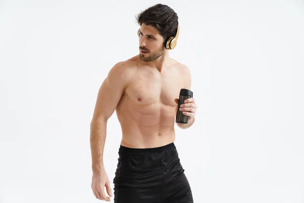 Hemdloser Sportler Mit Kopfhörern Posiert Mit Wasserflasche Isoliert Über Weißem — Stockfoto