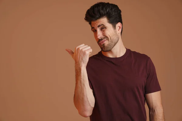 Homem Masculino Confuso Posando Apontando Dedo Isolado Sobre Fundo Bege — Fotografia de Stock
