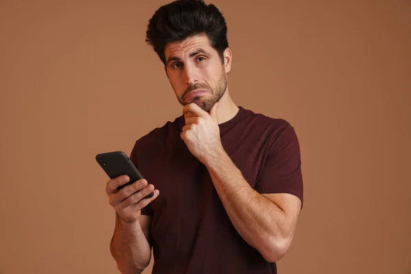 Brooding Masculine Man Using Mobile Phone While Posing Camera Isolated — Stock Photo, Image