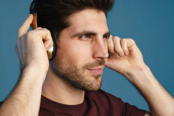 Zadowolony Przystojny Mężczyzna Słuchanie Muzyki Bezprzewodowymi Słuchawkami Izolowane Niebieskim Tle — Zdjęcie stockowe