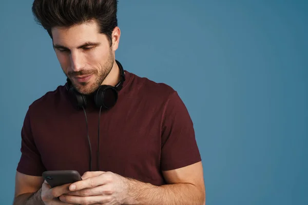 Nöjd Stilig Man Med Hörlurar Med Mobiltelefon Isolerad Över Blå — Stockfoto