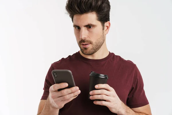 Astonished Handsome Man Drinking Coffee Using Mobile Phone Isolated White — Stock Photo, Image