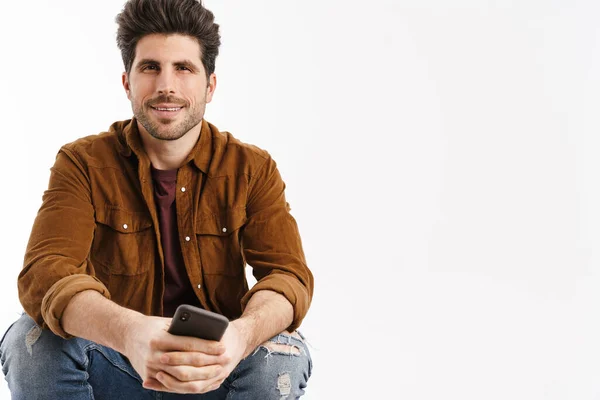 Agradable Hombre Guapo Sentado Con Teléfono Móvil Aislado Sobre Fondo — Foto de Stock