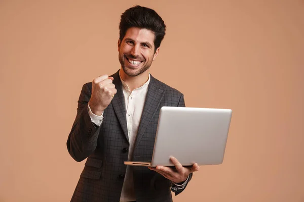 Excited Man Making Winner Gesture While Working Laptop Isolated Beige — Stock Photo, Image