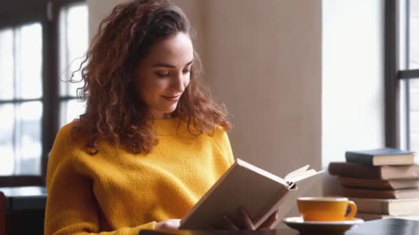 Красивая Женщина Читает Книгу Сидя Кафе Внутри — стоковое видео