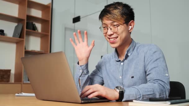 Happy Chinese Man Earbuds Talking Video Call Laptop Actively Gesturing — Stock Video