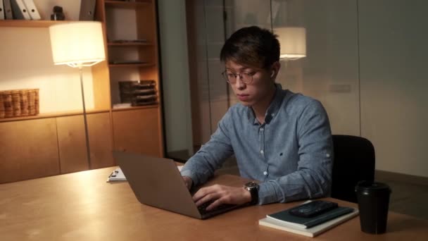 Geconcentreerde Chinese Man Typt Iets Laptop Kijkt Naar Zijkant Terwijl — Stockvideo