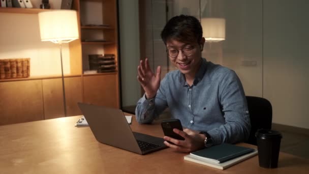 Uśmiechnięty Chińczyk Rozmawiający Przez Telefon Przez Wideo Machający Kamery Siedząc — Wideo stockowe