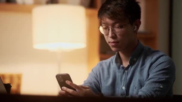 Het Zijaanzicht Van Een Aziatische Man Kijkend Naar Telefoon Terwijl — Stockvideo